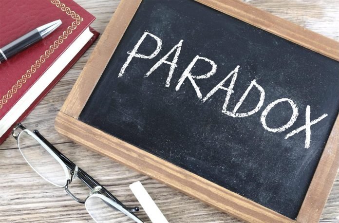 Jevon’s Paradox: How Conversational AI Turns Efficiency into Growth Chalkboard showing the word “Paradox” with notebook and glasses