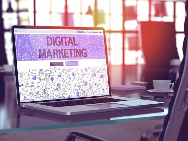 Laptop displaying digital marketing visuals in modern office.
